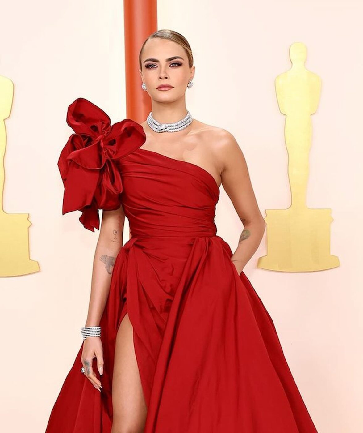 Cara Delevigne Oscar 2023 com vestido chique vermelho.