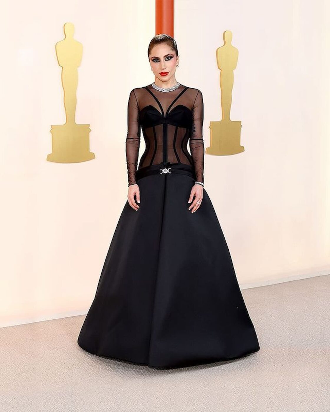 Lady Gaga usando um vestido preto da Versace no Oscar.