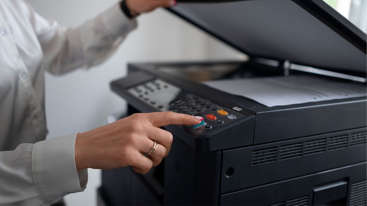 Pessoa usando uma impressora em um escritório.